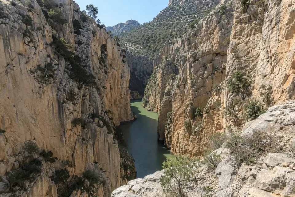 De rivier onder de steile kloofwanden