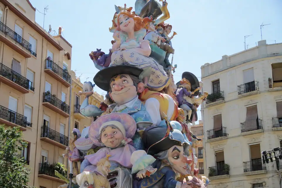 Een vier verdiepingen hoog gekleurd beeld van papier-maché vult een klein plein tussen flats.